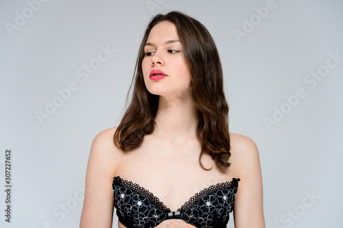 Wallpaper Mural Concept adult girl on a white background. Large photo of a pretty brunette girl with excellent facial skin in a black bra smiles and shows different emotions in different poses. Torontodigital.ca