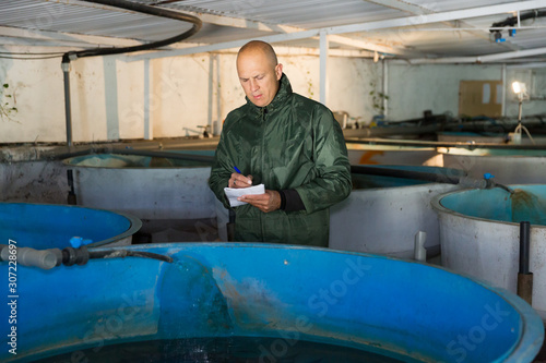 Man inspecting tanks for rearing trout fry