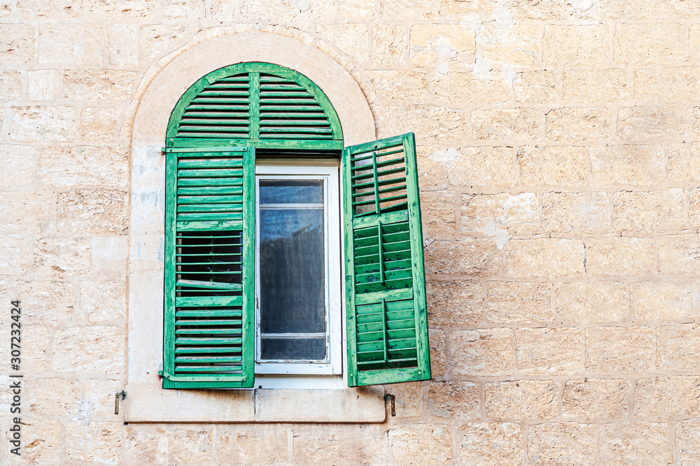 vintage background of a window with shutters in an old stone house with copy space