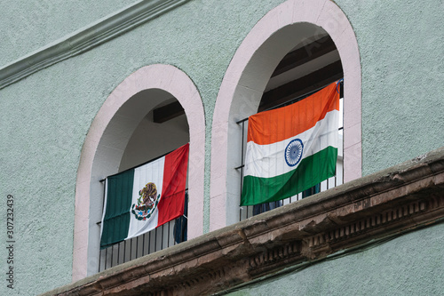Flags of Mexico and India placed on the facade of a Mexican house.