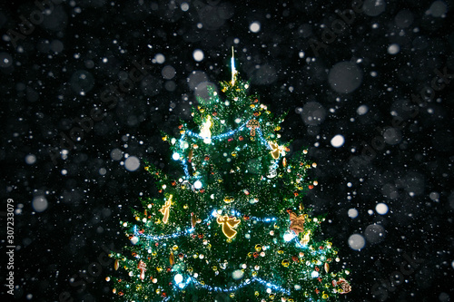 New Year tree and falling snow at night. Christmas background