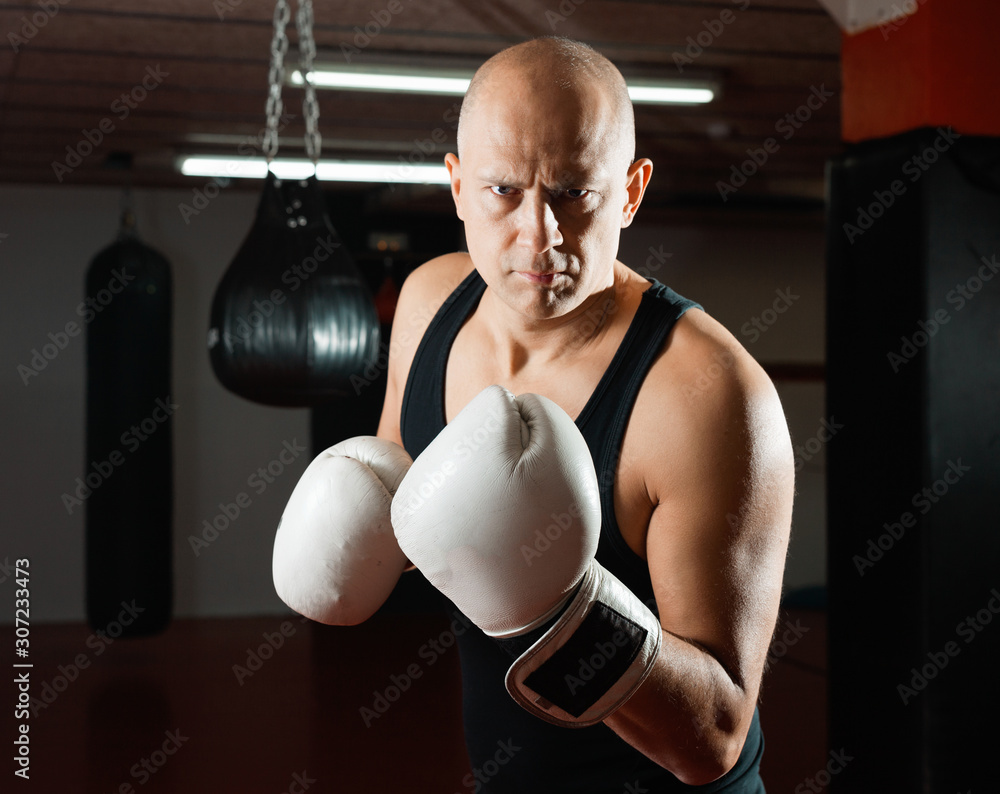 Potrait of man boxer who is training in gym