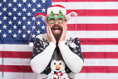 I am so happy. Christmas in usa. Live your dreams. Santa at american flag. Bearded american man celebrate new year. National us flag. Patriotic spirit. American man celebrate winter holiday © be free