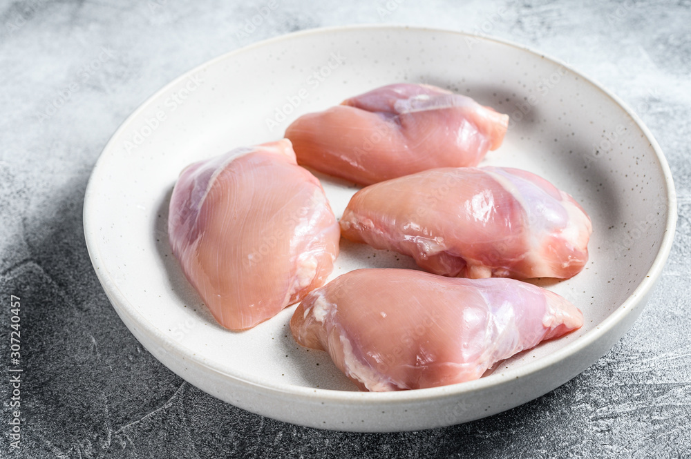 Raw chicken thigh fillet. Gray background. Top view