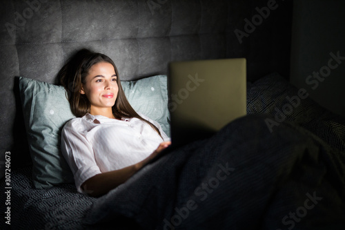 Young woman feeling tired with using cellphone at night