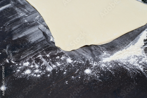 dough on a black table with flour