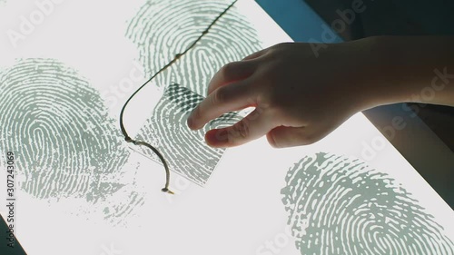 Children hands are checking the fingerprint at the school of forensics photo