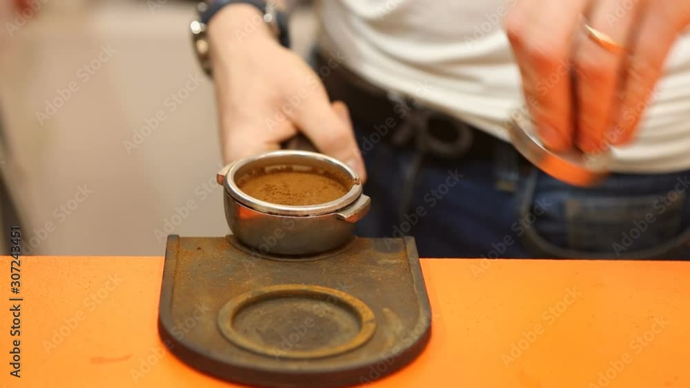 Barista presses coffee in the horn Barista presses coffee in the horn