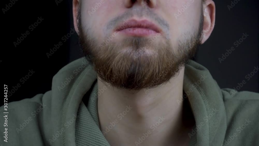 the guy eats delicious pizza. close-up of a mouth chewing a slice of pizza. a bearded man is eating. the guy eats delicious pizza. close-up of a mouth chewing a slice of pizza. a bearded man is eating.