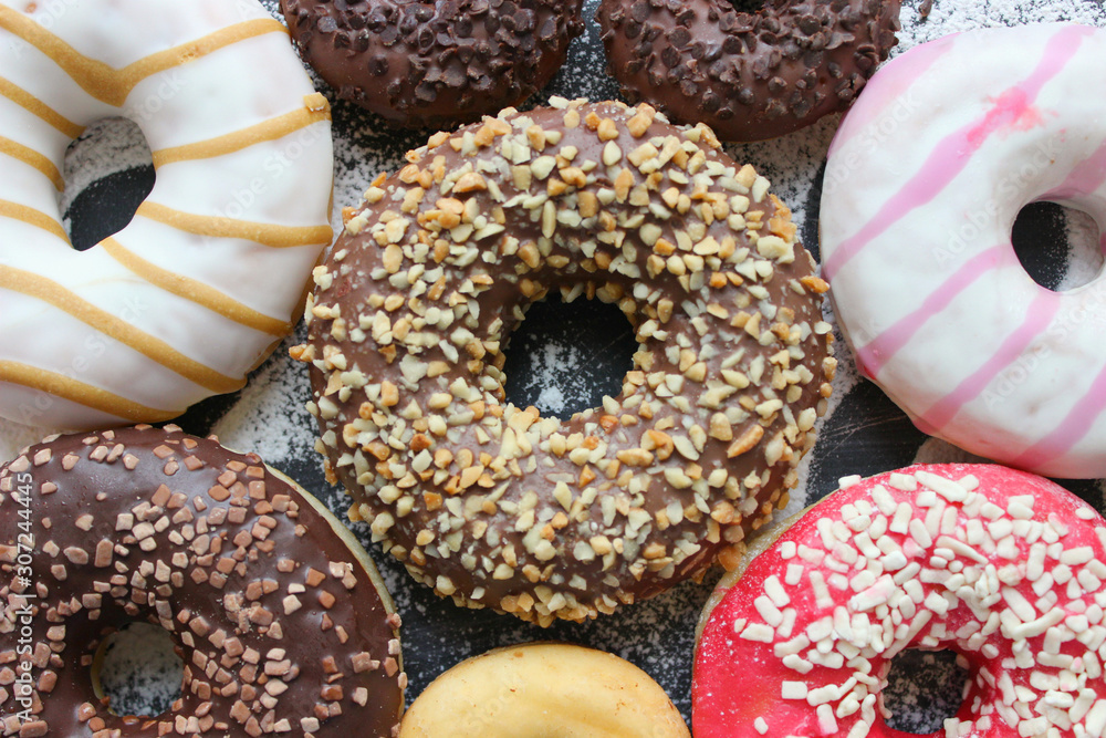 Various donuts on white background, from above. 