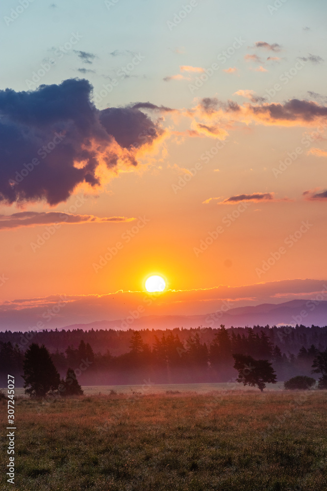 Beautiful sunrise on Slovakian meadow, orange look, with clouds