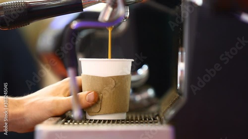 The Barista pours coffee into a paper Cup