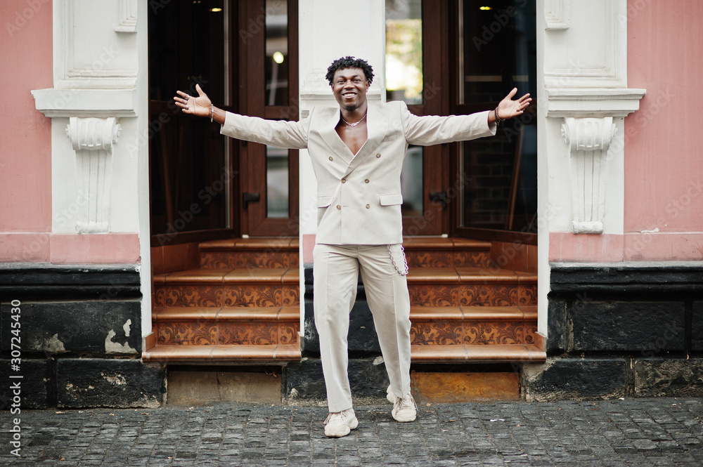 Stylish afro man in beige old school suit. Fashionable young African male in casual jacket on bare torso. Stylish afro man in beige old school suit. Fashionable young African male in casual jacket on bare torso.