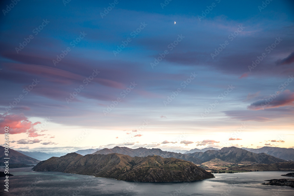 Fototapeta premium Sunrise sky mountain landscape. Early dawn morning colorful sky with scenic view over mountains in New Zealand. Roys Peak Wanaka