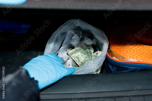 police finds a bag of money and drugs in the trunk of a detainee
