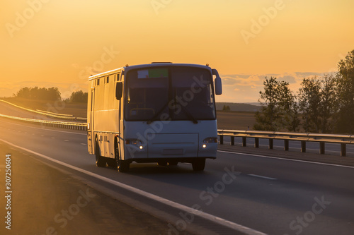 bus carries passengers on a suburban highway