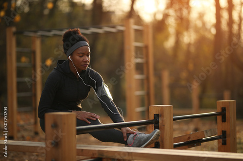 African American woman exercising at outdoor gym in the park.