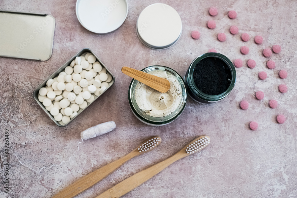High angle close up of wooden toothbrushes, homemade cosmetics and pills in metal box. High angle close up of wooden toothbrushes, homemade cosmetics and pills in metal box.