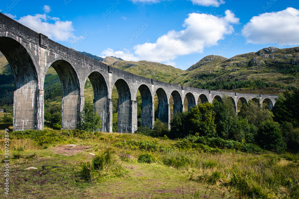 View on famous Glenfinnan viaduct with red Jacobi train, Scotland