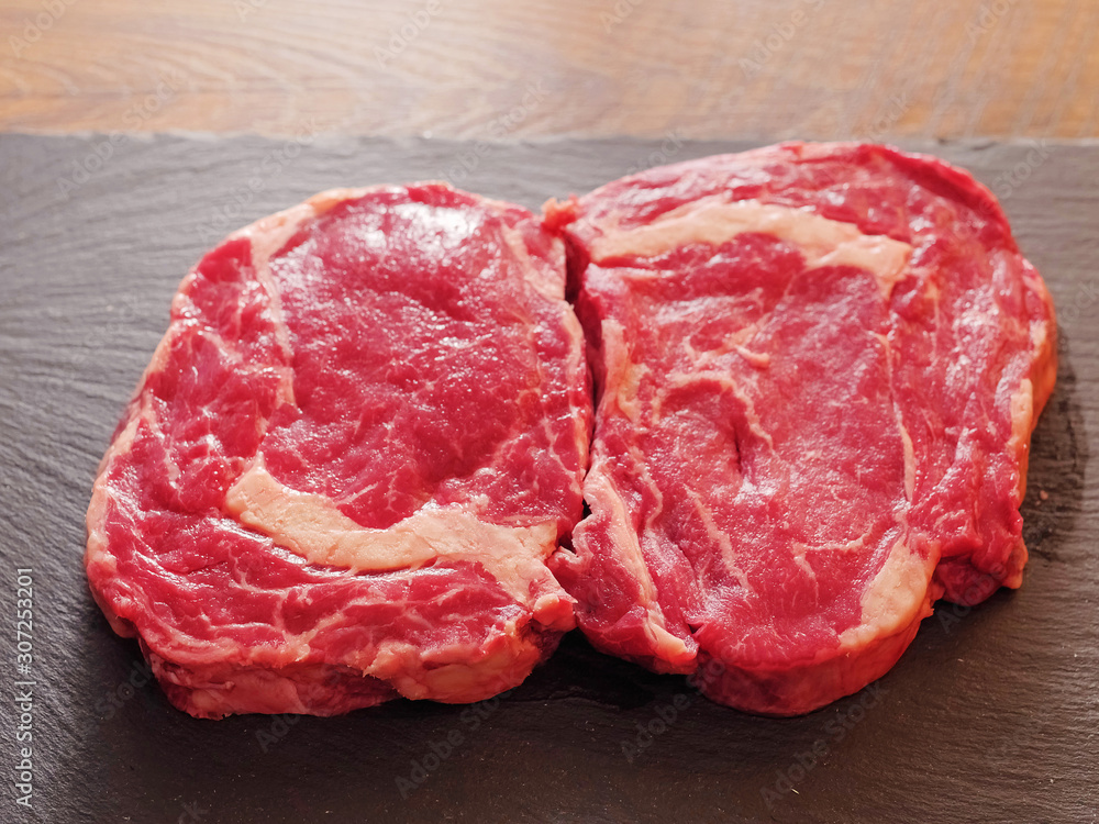 Two fresh uncooked raw beef rib eye steaks, Selective focus.