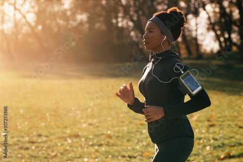 Obraz na płótnie Dedicated African American athlete jogging in nature.
