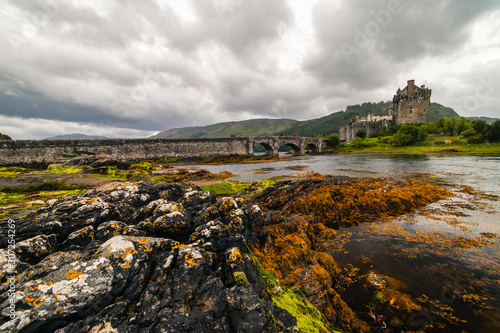 Magnificent Eilean Donan castle during cloudy weather at low tide