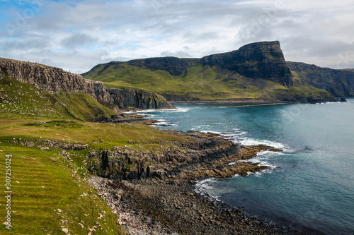 View on green grass filled coastal in Scotland near Nest Point famous lighthouse, Isle of Skye