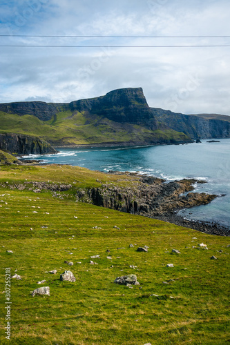 View on green grass filled coastal in Scotland near Nest Point famous lighthouse, Isle of Skye