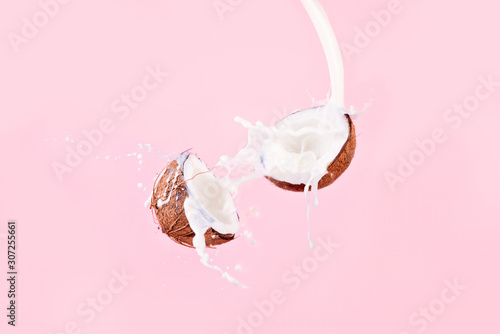 Fotobehang Coconut and spray of coconut milk over pink background, Broken coconut levitatio