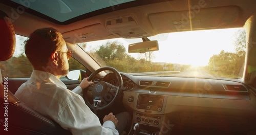 Wallpaper Mural Video for Animating. Male adult bearded driver tapping cyber space dashboard screen, driving futuristic elegant car towards the sun rifing over the road. Nanotechnology. Auto control. Navigate. Torontodigital.ca