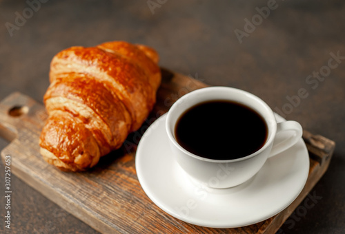 coffee and croissant on a stone table with copy space for your text, early breakfast concept