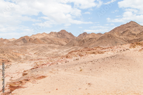 Desert, red mountains, rocks and cloudy sky. Egypt, color canyon.