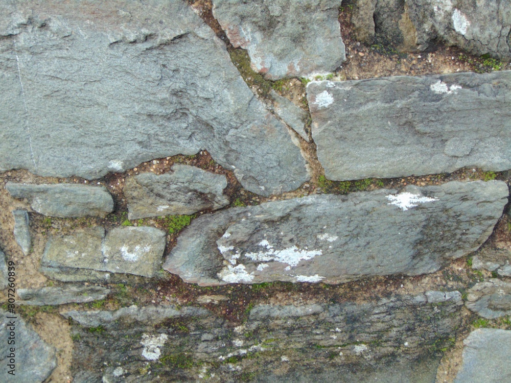 Old stone wall with moss and stones. Masonry walls in medieval Italian style. Close-up, background. Old stone wall with moss and stones. Masonry walls in medieval Italian style. Close-up, background.