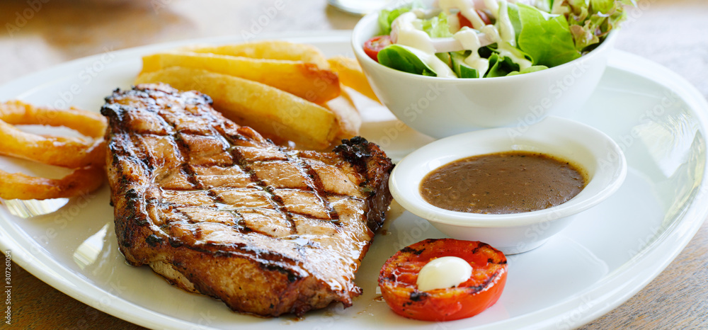 thick pork steak with gravy, salad and hand cut fries thick pork steak with gravy, salad and hand cut fries