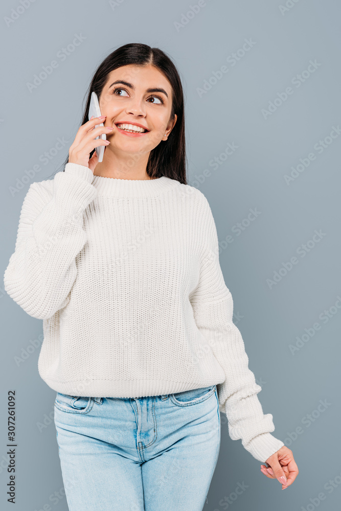 smiling pretty brunette girl in white sweater talking on smartphone isolated on grey smiling pretty brunette girl in white sweater talking on smartphone isolated on grey