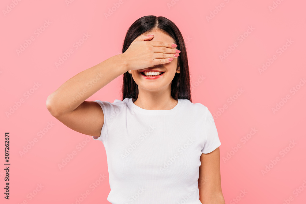 happy pretty brunette girl covering eyes with hand isolated on pink happy pretty brunette girl covering eyes with hand isolated on pink