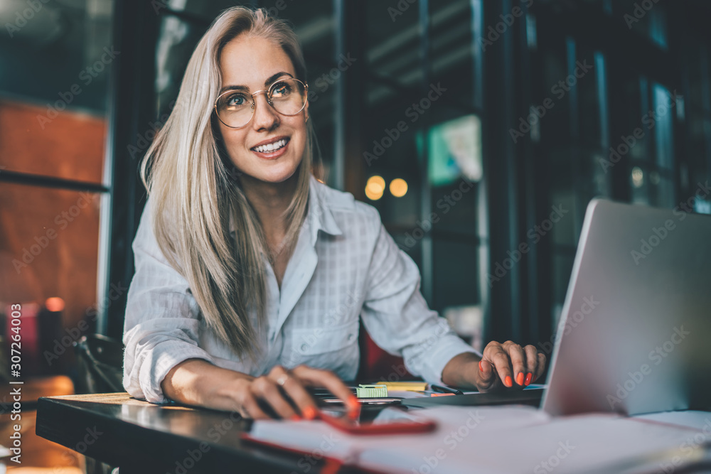 Friendly female using laptop and smartphone in cafe Friendly female using laptop and smartphone in cafe