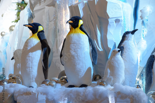 Toy penguins on north pole are waiting for new year. Installation with penguins  ice  snow and Christmas Holiday Balls.
