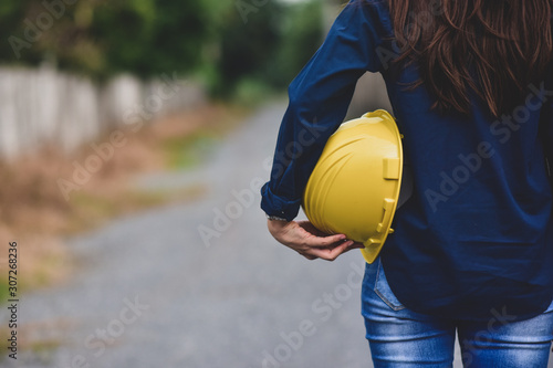 Engineering hold yellow hard hat safety work place outdoors background