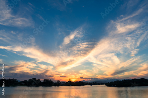 Beautiful sunset sky with colorful clouds over river © Olga K