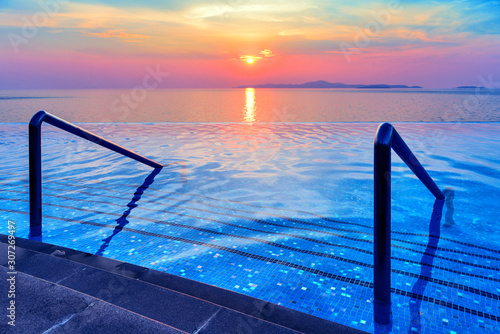Swimming pool with stair and sunset background