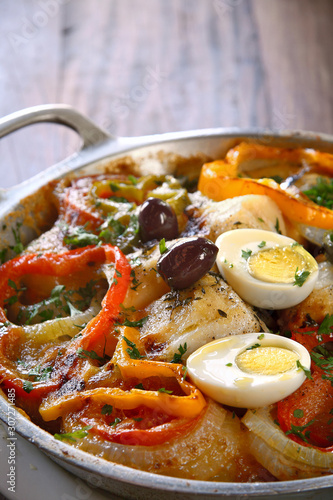 Codfish in the wood served in iron pan photo