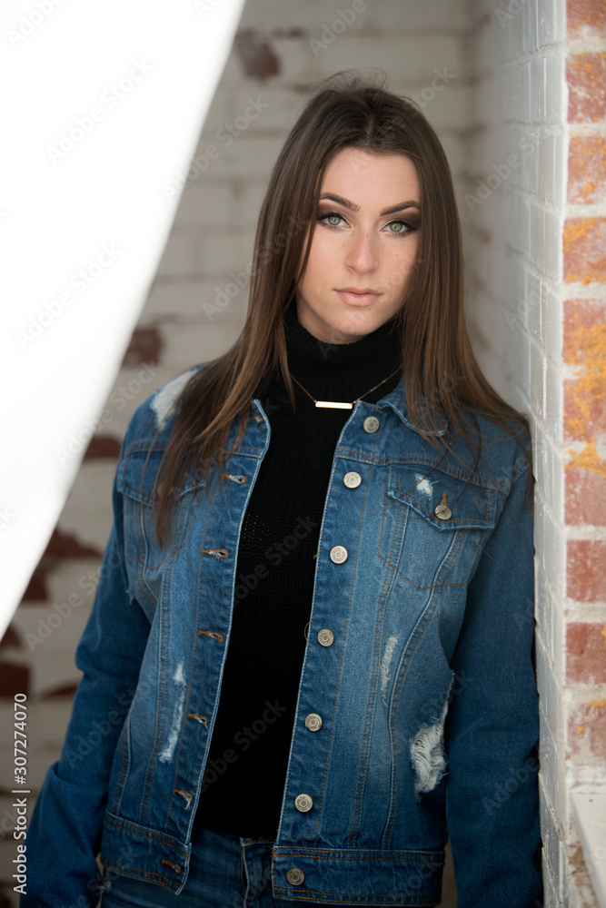 Stunning young brunette woman wearing denim jacket, black turtleneck  fashion headset near drapery Stock Photo | Adobe Stock