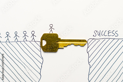 Group of tiny people walking through a golden key to success photo