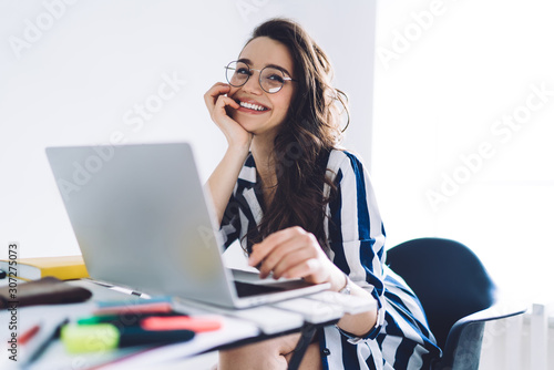 Laughing woman sitting at table with laptop