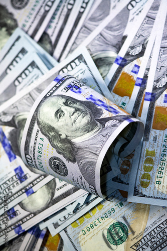 Franklin Portrait Close-up with curved hundred dollar bill on dollars background