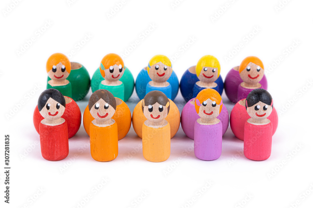 A close-up of a children's toy made of natural wood in the form of little people of different colors with a smile is standing in an even row on a white isolated background. A close-up of a children's toy made of natural wood in the form of little people of different colors with a smile is standing in an even row on a white isolated background.