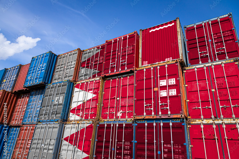 Fototapeta premium The national flag of Bahrain on a large number of metal containers for storing goods stacked in rows on top of each other. Conception of storage of goods by importers, exporters