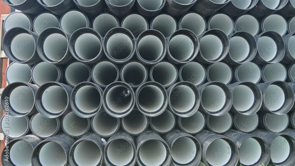 Warehouse of finished plastic pipes industrial outdoors storage site. Manufacture of plastic water pipes factory. Process of making plastic tubes on the machine tool with the use of water and air Warehouse of finished plastic pipes industrial outdoors storage site. Manufacture of plastic water pipes factory. Process of making plastic tubes on the machine tool with the use of water and air