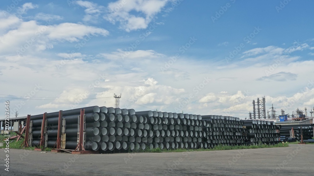 Warehouse of finished plastic pipes industrial outdoors storage site. Manufacture of plastic water pipes factory. Process of making plastic tubes on the machine tool with the use of water and air Warehouse of finished plastic pipes industrial outdoors storage site. Manufacture of plastic water pipes factory. Process of making plastic tubes on the machine tool with the use of water and air